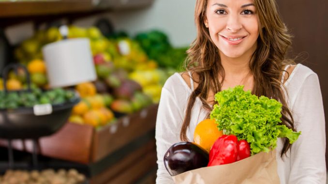 אישה מחזיקה בסל ירקות